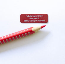 Laden Sie das Bild in den Galerie-Viewer, Drohnenkennzeichen 30×10 mm in Alu Rot mit weißer Gravur, im Größenvergleich neben einem roten Stift